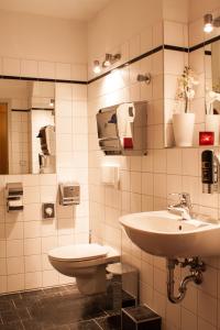 a bathroom with a sink and a mirror at Hotel Ambiente Berlin City in Berlin