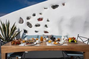 un tavolo con piatti di cibo sopra di Remezzo Villas a Imerovigli
