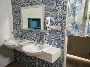 a bathroom with two sinks and a mirror at Yes, Sir Homestay in Nangan