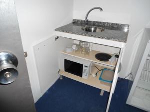 a small kitchen with a sink and a microwave at Complejo Turistico Anaconda Hotel in La Paloma