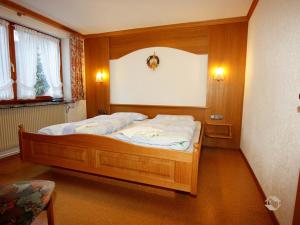 1 dormitorio con cama de madera en una habitación en Schwarzwaldhaus Simmelehof, en Lenzkirch