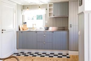 ビンメルビューにあるAstrid Lindgrens Världs Gästboendeのチェッカー付きの床、シンク付きのキッチンが備わります。