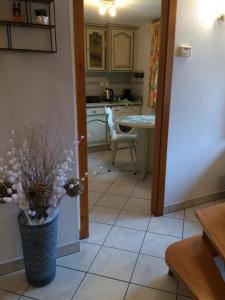 a kitchen with a vase of flowers on a tile floor at Gîte "Smart'In" in Eguisheim