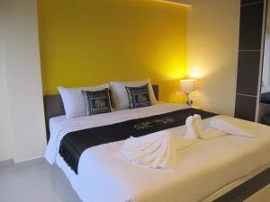 a bedroom with a large bed with white sheets at Suvarnabhumi Oriental Resort in Lat Krabang