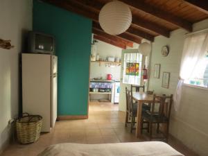 eine Küche und ein Esszimmer mit einem Tisch und einem Kühlschrank in der Unterkunft La Casa De La Abuela Departamentos in El Bolsón + 25 Fotos