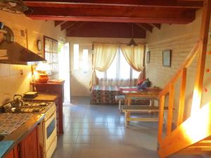 a kitchen with a stove and a table in a room at La Casa De La Abuela Departamentos in El Bolsón
