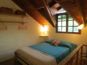a bedroom with a bed in a room with a window at La Casa De La Abuela Departamentos in El Bolsón