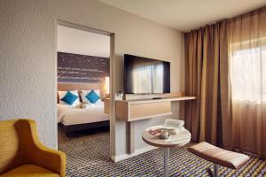 een hotelkamer met een bed en een spiegel bij Mercure Paris Sud Les Ulis-Courtaboeuf in Les Ulis
