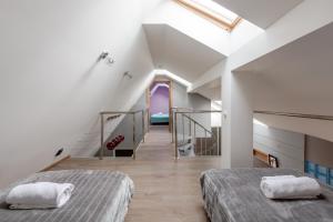 a attic bedroom with two beds and a staircase at Penthouse Apartment with Terrace in Rīga