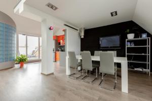 a dining room with a white table and chairs at Penthouse Apartment with Terrace in Rīga