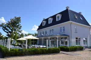 a large white building with an umbrella in front of it at Fletcher Hotel-Restaurant Duinzicht in Ouddorp