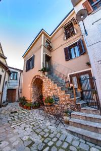 a building with stairs and chairs in front of it at La Finestra Sui Cento Portali in Pignola