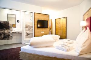 a hotel room with a bed with towels on it at Hotel Garni Arosa in Ischgl