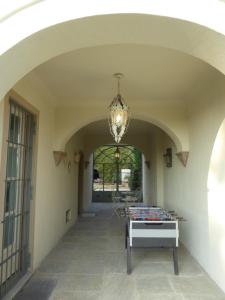 pasillo con lámpara de araña y mesa en B&B Villa Ricardi en Moncalieri