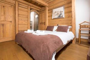 a large bed in a room with wooden walls at Le Kursaal Apartment - Chamonix All Year in Chamonix