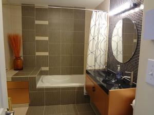 a bathroom with a tub and a sink and a mirror at Hotel Saint-Donat in Saint-Donat-de-Montcalm