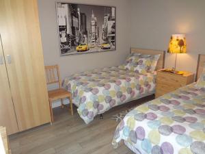 una camera con 2 letti, una lampada e una sedia di Hotel Saint-Donat a Saint-Donat-de-Montcalm