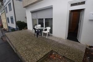 um pátio com 2 cadeiras e uma mesa na varanda em Apartment Stuttgart Kaltental em Estugarda