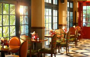 a dining room with tables and chairs and windows at The Royale Senate Race Course, Bangalore in Bangalore