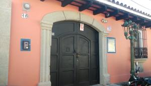 an orange building with a large black door at Hotel La Villa Serena in Antigua Guatemala