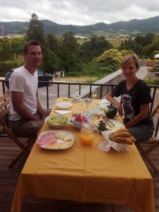 a man and a woman sitting at a table with food at Casa da Cisaltina in Povoação