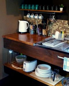 een aanrecht met een wastafel en borden op een plank bij Posta Chimango, Cabañas frente al Golf Los Acantilados in Mar del Plata +30 foto's