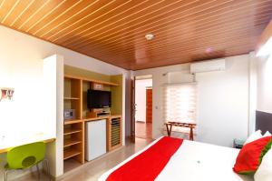 a living room with a bed and a tv at Waira Suites in Leticia