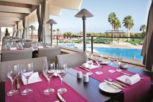 a dining room with a table with wine glasses and a pool at Eurotel Altura in Altura