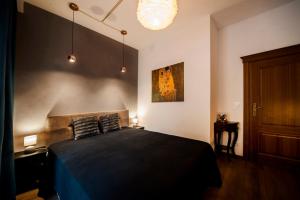 a bedroom with a large bed with a black blanket at Very Berry - Orzeszkowej 10 - MTP Apartment, parking, balcony, check in 24h in Poznań