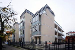 a white building with a black fence in front of it at Very Berry - Orzeszkowej 10 - MTP Apartment, parking, balcony, check in 24h in Poznań