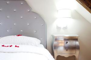 um quarto com uma cama branca e uma mesa de cabeceira em madeira em Dolce Vita Suites Boutique em Praga