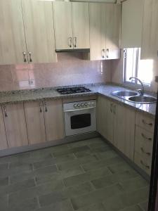 eine Küche mit weißen Schränken und einem Herd und einer Spüle in der Unterkunft Chalet piscina jakuzzi sevilla in Hacienda de Tarazona