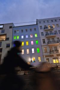 a building with green and colorful windows at night at Old Town Hostel in Berlin