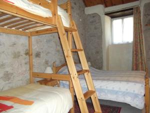 - un lit superposé en bois avec une échelle à côté d'un lit superposé dans l'établissement Ferme Auberge La Tindelle, à La Cresse