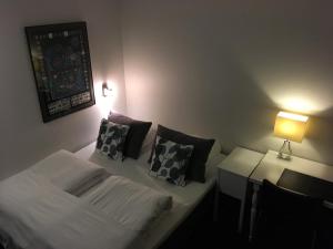 a room with a bed and a table with a lamp at Hotel Liselund in Nykøbing Falster