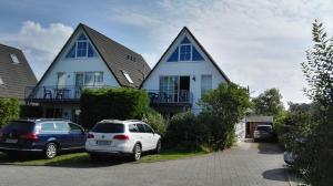 two cars parked in front of a house at Ferienwohnung Haus Sommerwind in Juliusruh