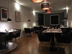 a dining room with tables and chairs and lights at Hotel Liselund in Nykøbing Falster
