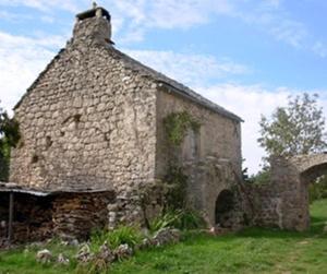 an old stone building sitting in a field at Ferme Auberge La Tindelle in La Cresse