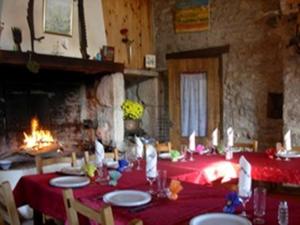 a dining room with a table with a red table cloth at Ferme Auberge La Tindelle in La Cresse