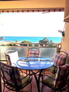 a table and chairs on a balcony with a view of the ocean at Apartamento PuigVal in El Puig