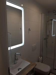 La salle de bains est pourvue d'un lavabo et d'une douche avec un miroir. dans l'établissement Hotel Haus Büderich, à Meerbusch