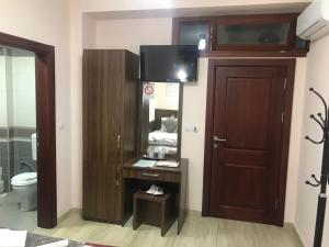 baño con puerta de madera y espejo en Prenociste DM5 en Novi Pazar