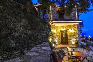 a stone house with a table and chairs in front of it at Voreio Selas in Synikia Mesi Trikalon