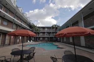 a swimming pool with tables and chairs and umbrellas at Midtown Hotel New Orleans in New Orleans