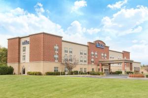 an exterior view of a hospital with a lawn at Baymont by Wyndham Plymouth in Plymouth