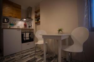 een keuken met witte stoelen en een tafel en een aanrecht bij Gramophone Sofia Downtown Apartment in Sofia
