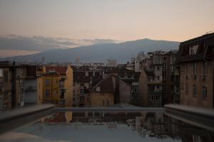 uitzicht op een stad met gebouwen en bergen bij Gramophone Sofia Downtown Apartment in Sofia