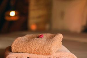 a pink towel with a red flower in it at Le Pacha Luxury Desert Camp - Mhamid Sahara Activities in Mhamid