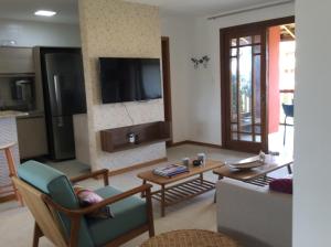 un soggiorno con una TV a parete di village na praia do forte a Praia do Forte