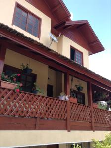 uma varanda de uma casa com vasos de plantas sobre ela em Hospedagem dona Tania em Canela
